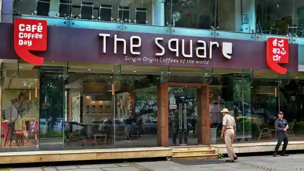 This image shows a person walking into the Square outlet of Cafe Coffee Day