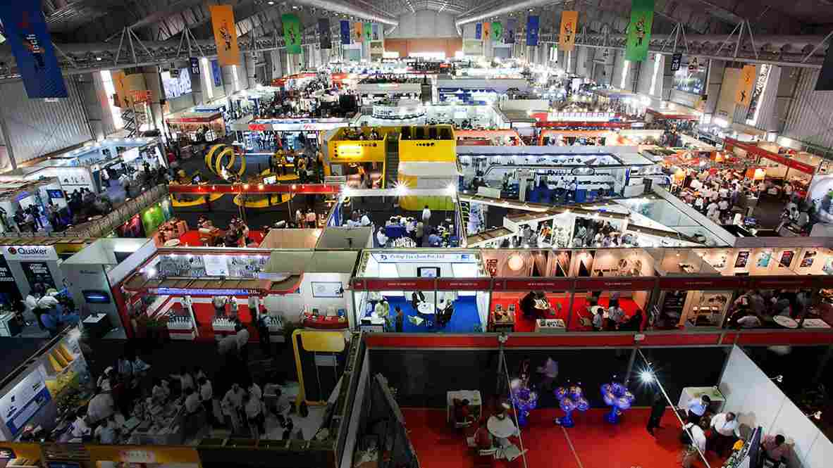 This image shows a trade fair in Delhi with several brands and people in one place