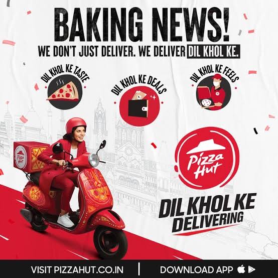 Anuradha Menon rides a scooty with a giant box of pizzas
