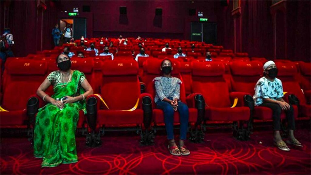 people seated in a cinema hall, looking at the screen