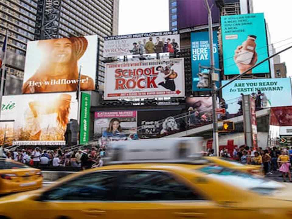 Numerous billboards being displayed on a busy street.