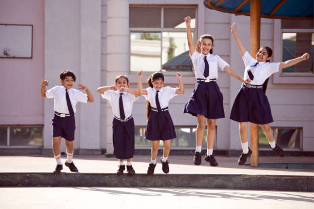 Children wearing the school uniform which has the logo.