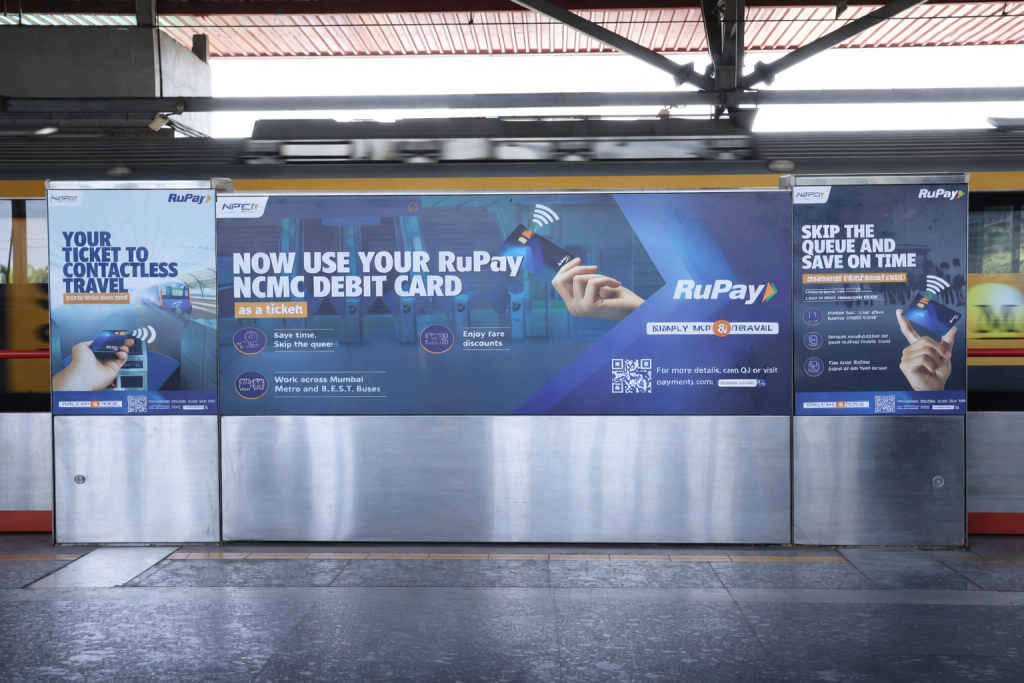 RuPay contactless travel advertisements installed along a metro platform barrier
