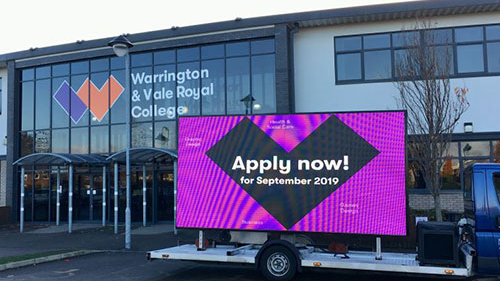 College Admission Campaign Using Mobile LED Van Advertising Mobile LED screen truck displaying “Apply now” message parked outside Warrington & Vale Royal College for admissions promotion.