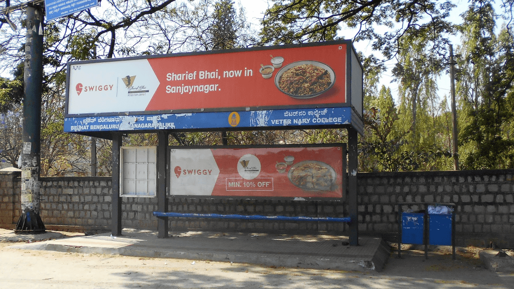 Swiggy food delivery advertisement placed at a bus shelter featuring local restaurant promotion and discount offer. Swiggy food delivery advertisement placed at a bus shelter featuring local restaurant promotion and discount offer.
