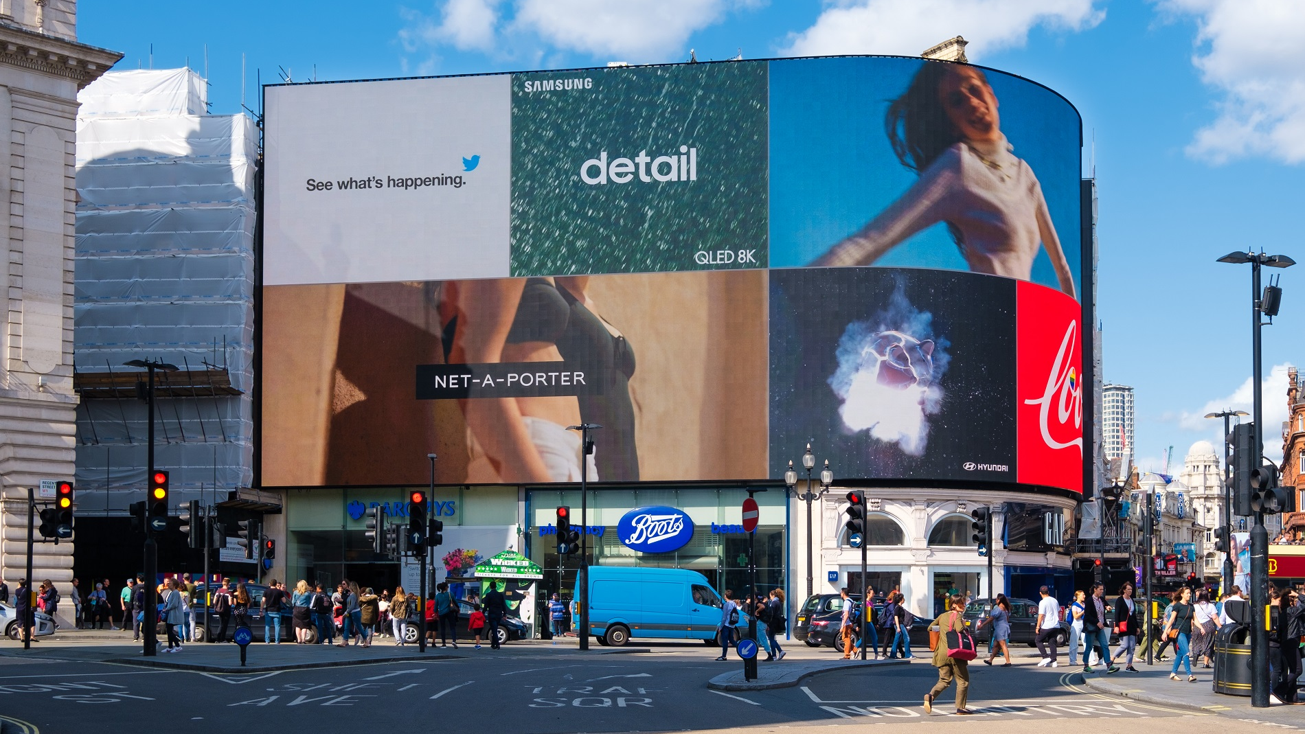 Digital out-of-home advertising for brand visibility and urban marketing Large digital billboard in a busy city displaying multiple brand advertisements showcasing programmatic OOH advertising