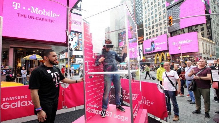 Outdoor experiential marketing event with a person inside a transparent booth demonstrating interactive brand activation in a city