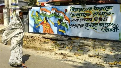 Trinamool Congress Election Campaign Wall Mural in Bengali | West Bengal Lok Sabha Elections Woman in saree walking past a Trinamool Congress (TMC) election campaign mural with Bengali text painted on a wall in West Bengal, India