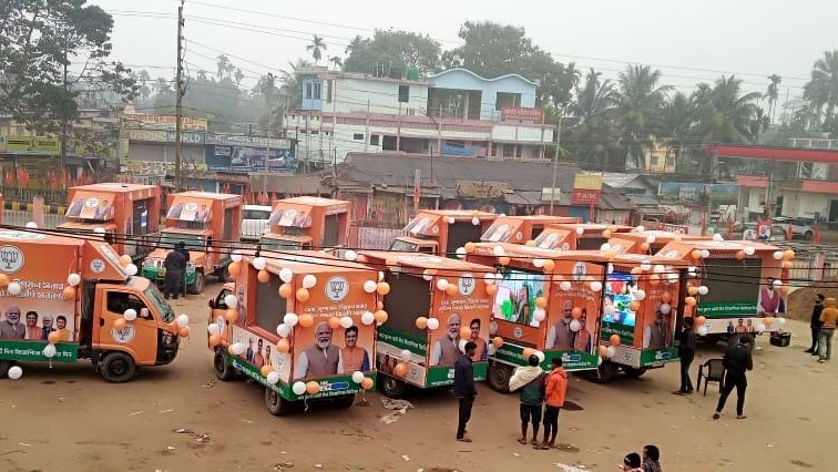 BJP Election Campaign Vehicles Fleet with Party Branding | Indian General Election Campaign Convoy Fleet of saffron-colored BJP campaign vehicles decorated with party flags and balloons lined up in a town square in India