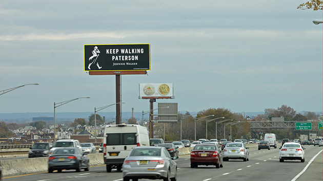 Johnnie Walker highway billboard campaign promoting brand message Johnnie Walker Keep Walking billboard on highway targeting drivers and commuters