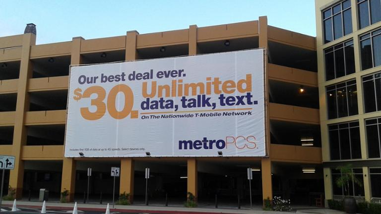 MetroPCS telecom billboard advertising unlimited plan offer MetroPCS billboard promoting unlimited data plan on building facade in urban area