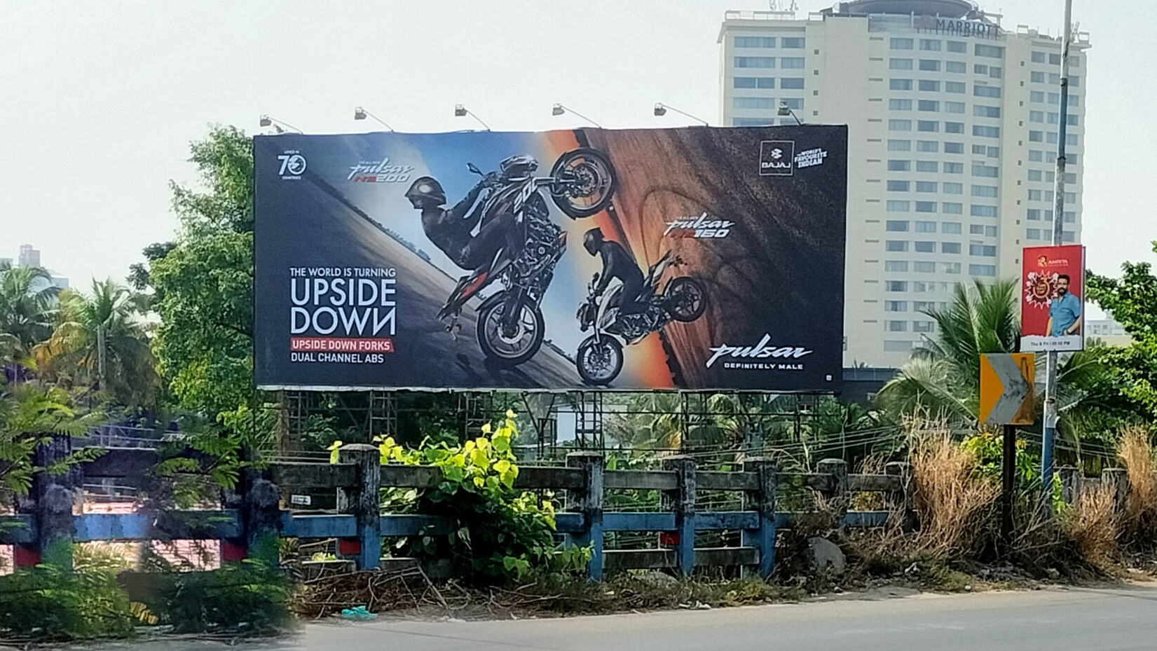 Bajaj Pulsar outdoor campaign with high-impact creative visuals Bajaj Pulsar motorcycle billboard featuring stunt visuals and upside down concept advertising