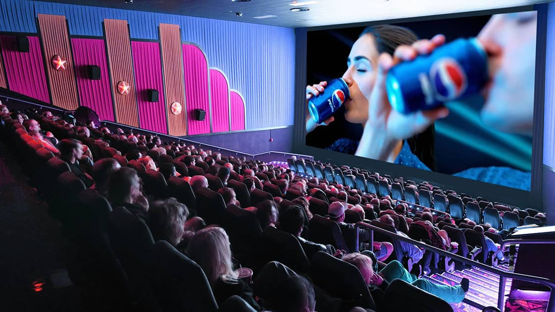 Cinema Screen Advertisement Before Movie Screening Crowded cinema auditorium where audiences watch a large screen advertisement featuring a beverage brand before the movie.