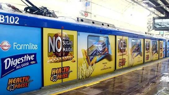 Sunfeast Farmlite Metro Train Advertising Wrap train exterior covered with Sunfeast Farmlite Digestive biscuit advertisements along the station platform.