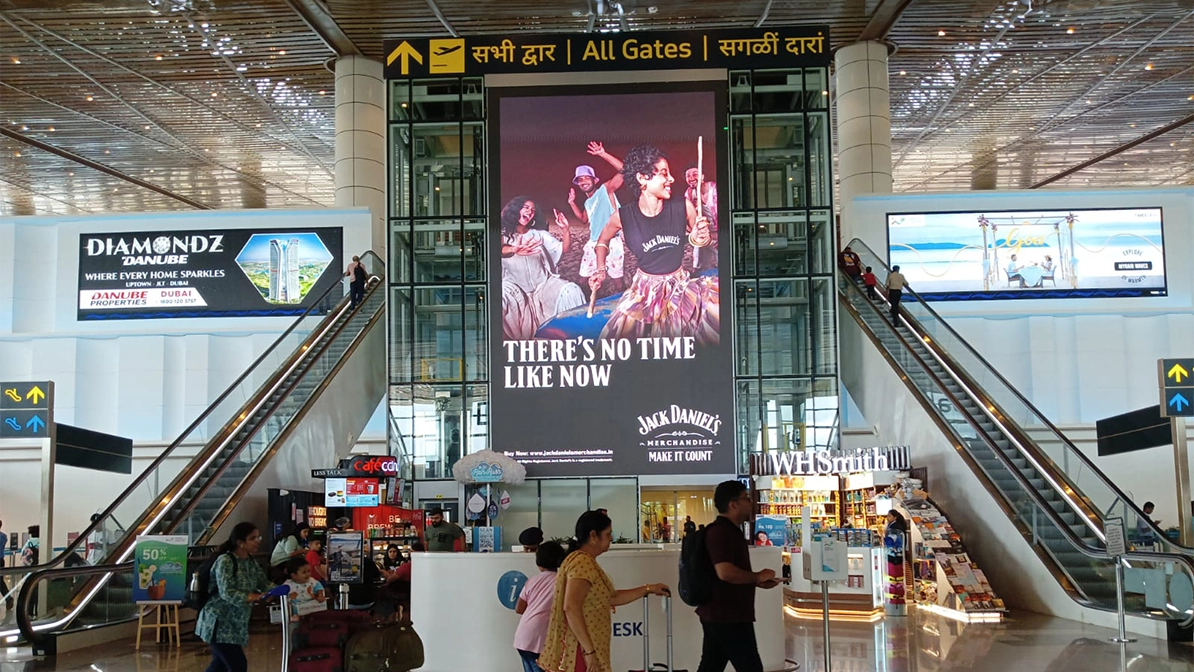 Jack Daniel’s Large Format Airport Digital Billboard Large vertical advertising screen for Jack Daniel’s whiskey placed between escalators in a busy airport terminal atrium.
