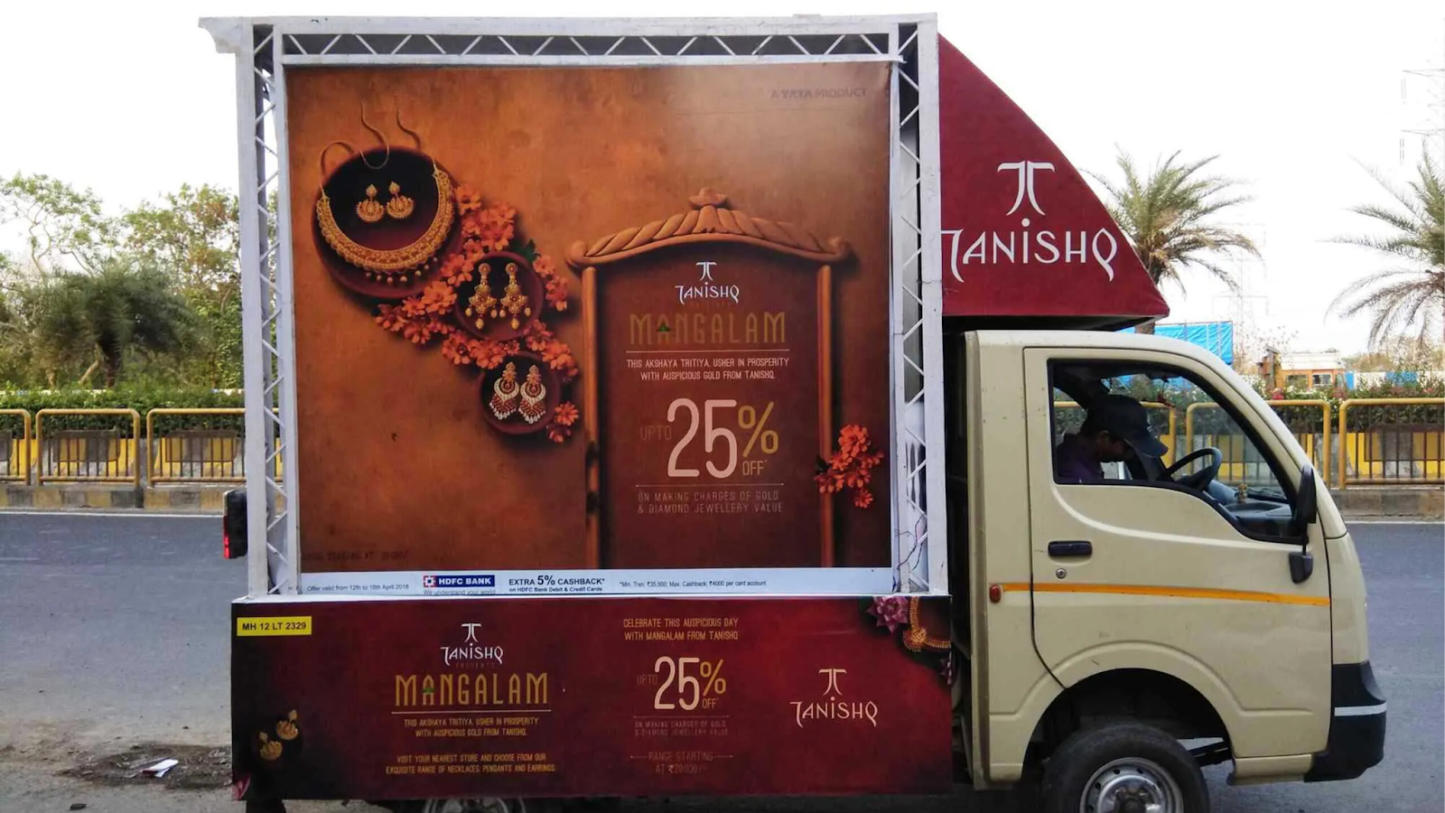 Tanishq Jewellery Mobile Billboard Truck Advertising Small advertising truck carrying a large Tanishq jewellery promotional display for Mangalam offers driving on a city road.