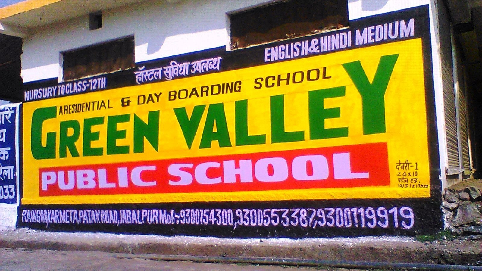 Green Valley Public School Wall Painting Advertisement Hand-painted wall advertisement for Green Valley Public School displaying school name, services, and contact details.